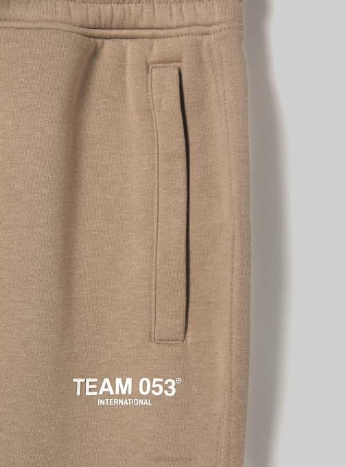 Heren Alcott bg1 beige donker joggingbroek met team 053 print kleding PT241174